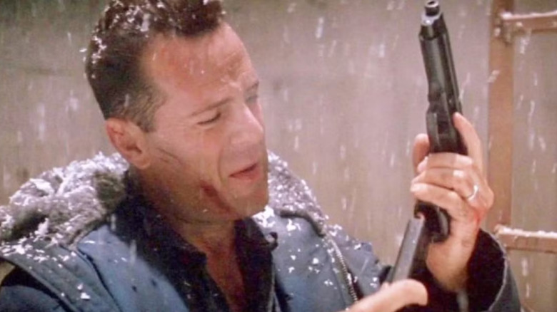 A snow-covered John McClane loads his gun in "Die Hard 2" (1990)