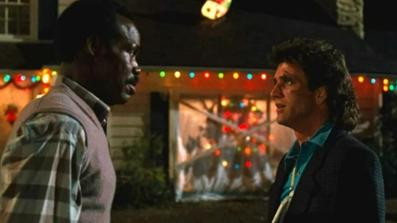 Murtaugh and Riggs talk outside of a house in "Lethal Weapon" (1987)