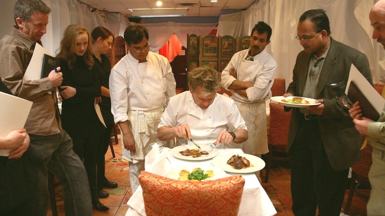 Chef Gordon Ramsay surrounded by people as he tries food at Dillon's in Kitchen Nightmares