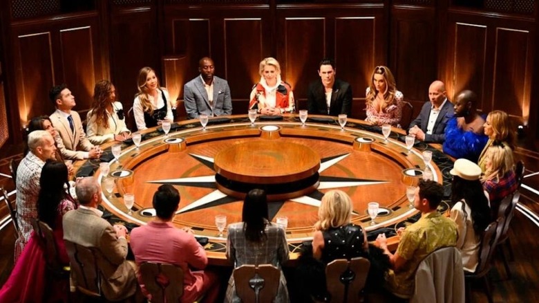 Contestants sitting around a large table in The Traitors (2023)