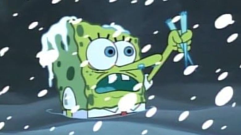 SpongeBob holding two icicles while chest-high in snow with more snow coming down against a night sky on SpongeBob SquarePants