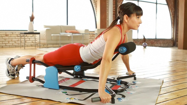 Woman using exercise machine on the floor