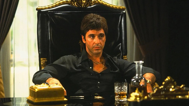 Tony Montana sitting behind desk