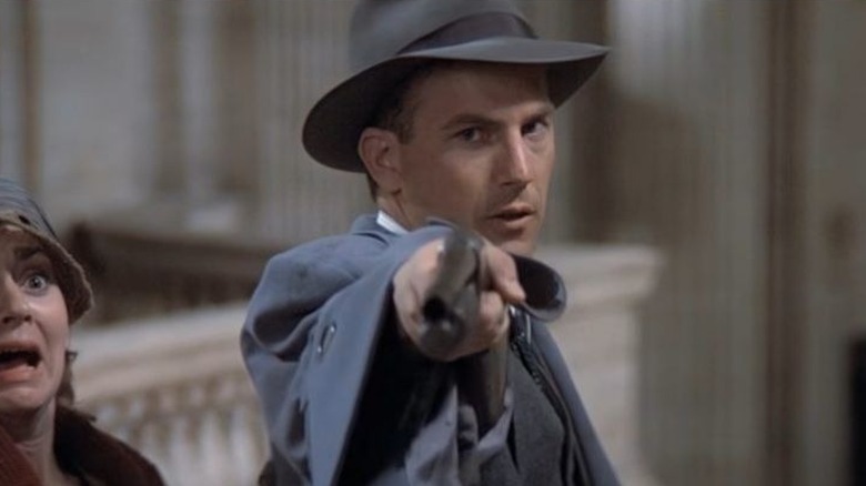 Eliot Ness pointing a shotgun