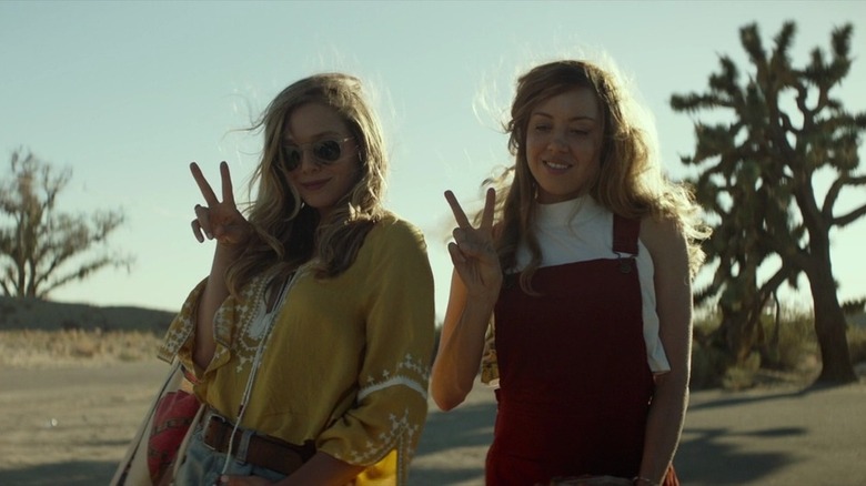 Elizabeth Olsen and Aubrey Plaza make peace signs