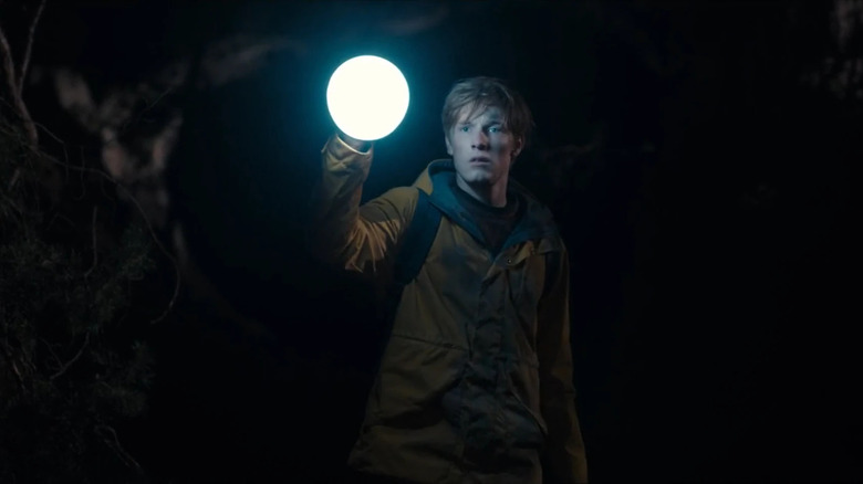 Man stands in cave with glowing ball of light