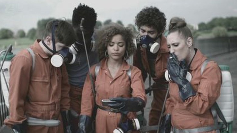 5 kids look at phone in prison jumpers and masks