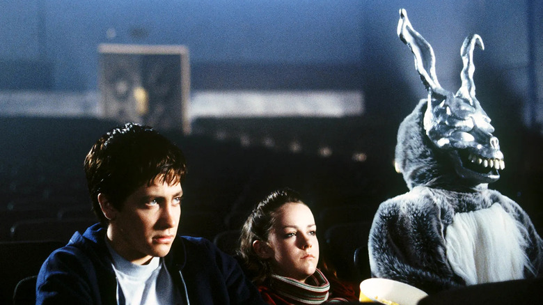 Donnie, Gretchen, and Frank sitting in a theater in "Donnie Darko" (2001)