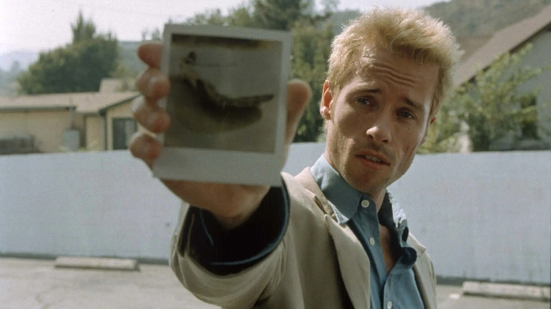 Leonard holds up a Polaroid in "Memento" (2000)