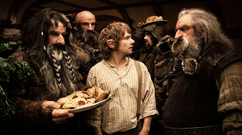 Bilbo surrounded by Dwarves