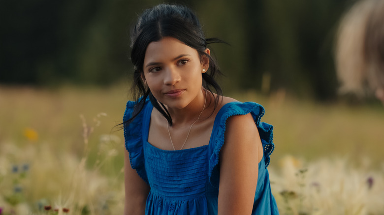 Jackie sitting in a field of wild flowers in 