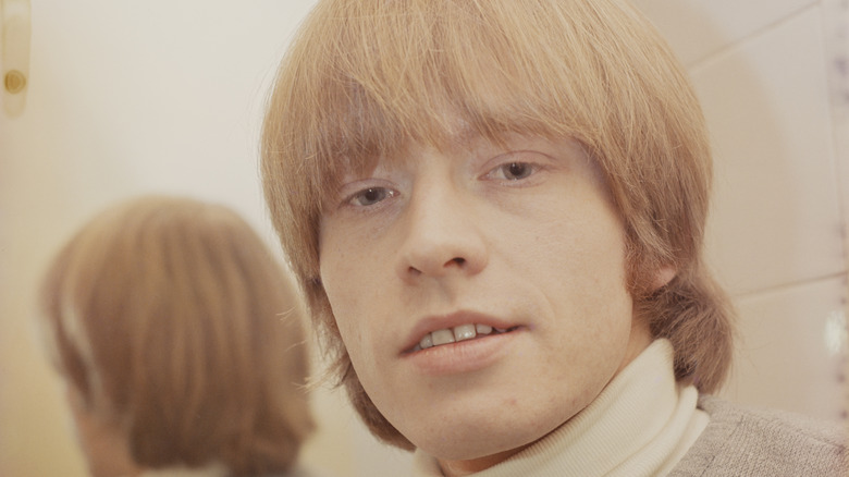 Brian Jones posing backstage in front of a mirror 1965