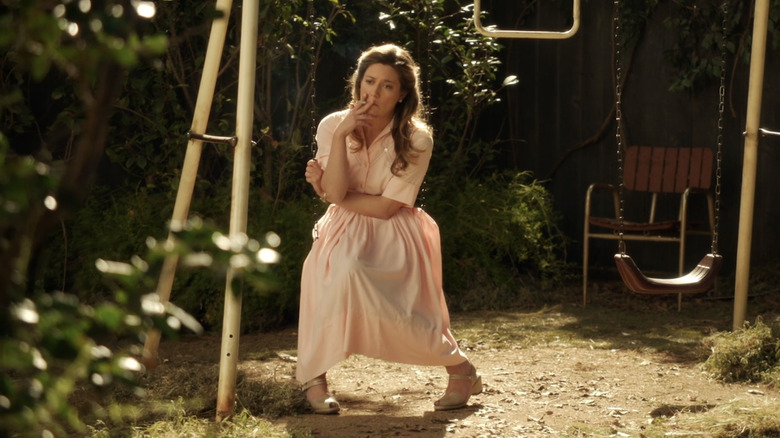 mary cooper sitting on swing smoking