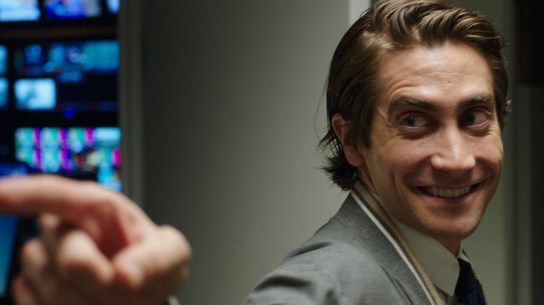 Louis Bloom points and smiles at someone in "Nightcrawler" (2014)