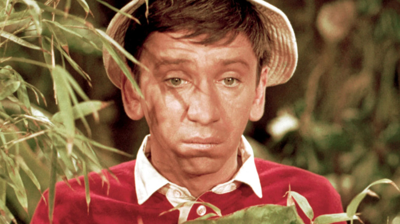 Gilligan sadly stands behind a bush on "Gilligan's Island" (1964-1967)