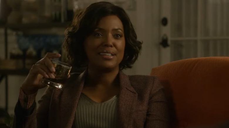 Tara holding glass of whiskey