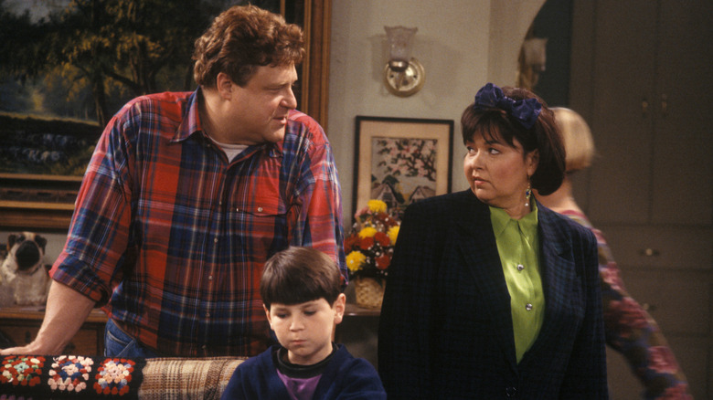 Dan and Roseanne Conner stare at each other while DJ Conner watches TV on "Roseanne"