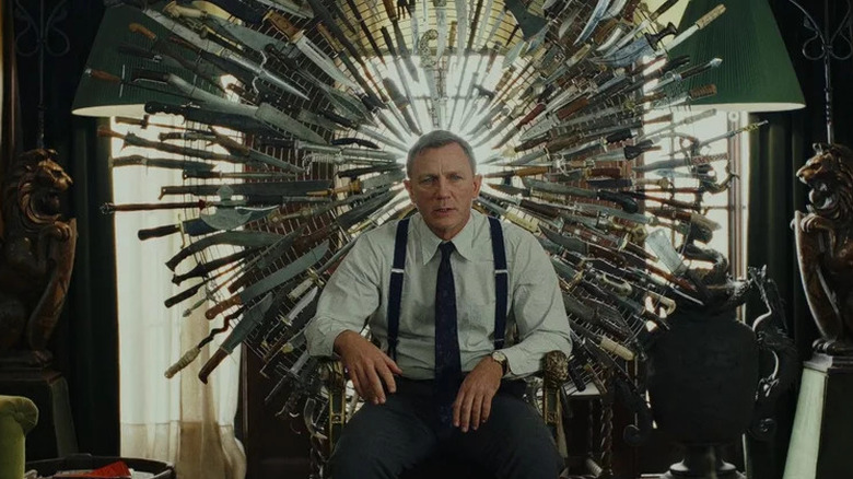 Daniel Craig sits near knives