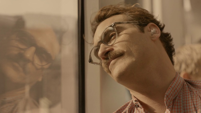 Joaquin Phoenix gazing out window and smiling