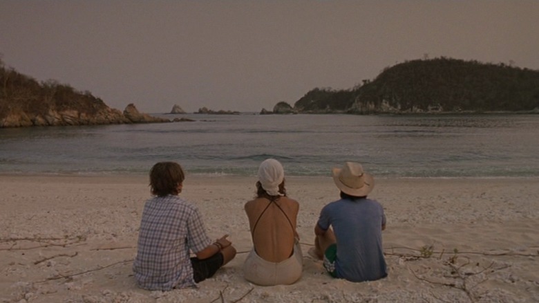 Diego Luna, Maribel Verdú, and García Bernal seated on beach from behind