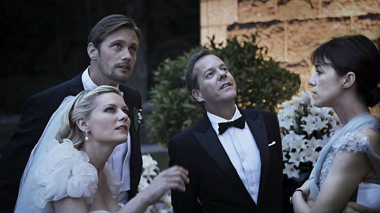 Justine in a wedding dress with her sister and their partners in Melancholia