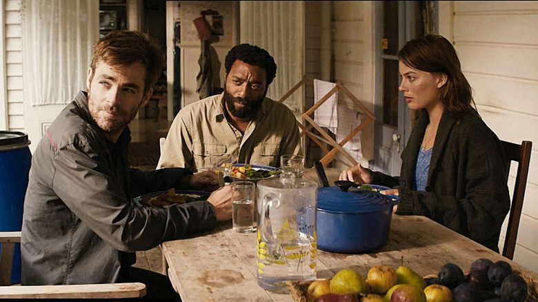 Ann sitting at the table with two male survivors in Z for Zachariah