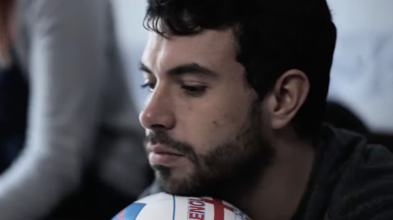 Man rests his head on soccer ball