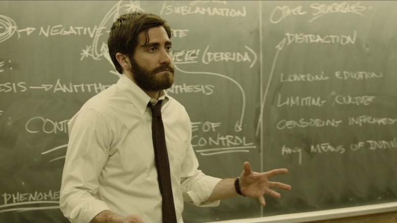 Adam Bell stands in front of a chalkboard in "Enemy" (2013)