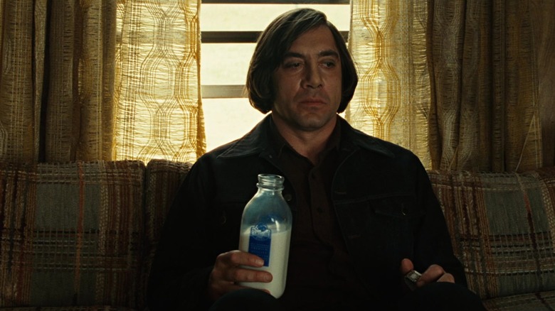 Anton Chigurh sits holding a milk bottle in "No Country for Old Men" (2007)