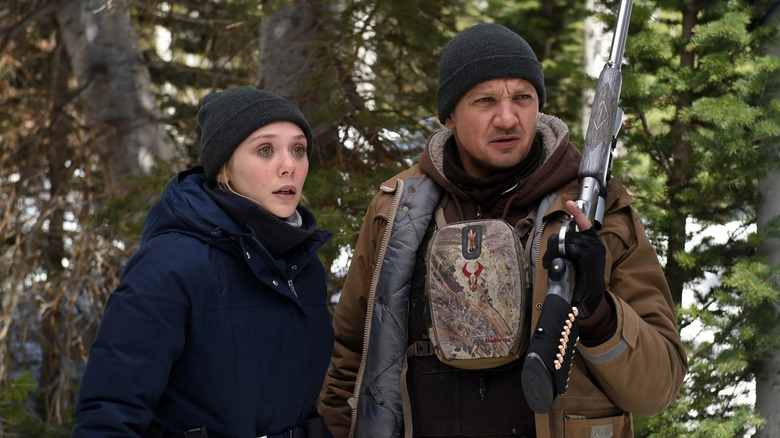 Jane and Cory walk through the wilderness in "Wind River" (2017)