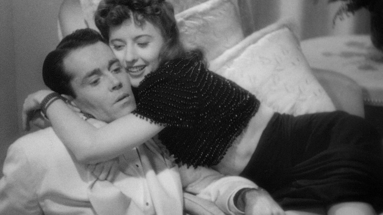 Barbara Stanwyck hugging Henry Fonda very tight