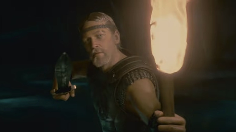 Beowulf holds torch and knife