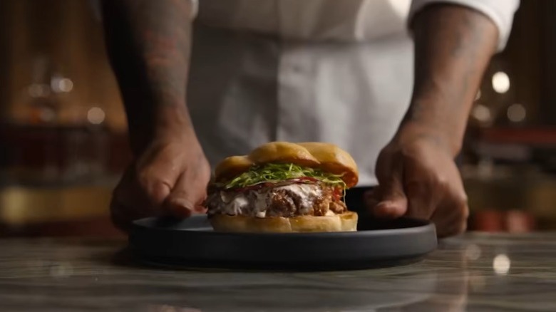 Chef hands serving sandwich on platter on Chef's Table