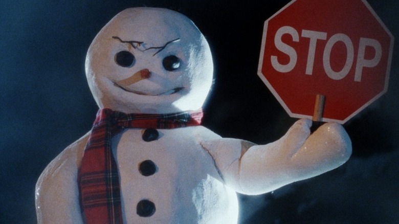 A snowman holds a stop sign