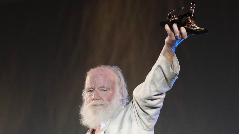 Phil Tippett holding up award