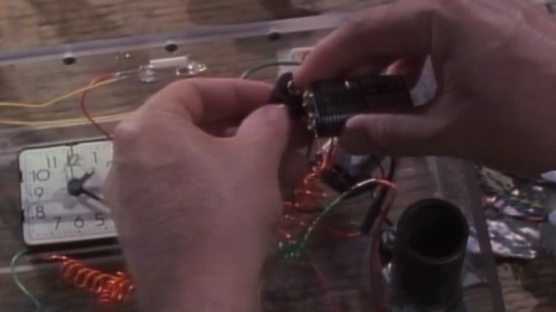 MacGyver's hands tinkering with a device