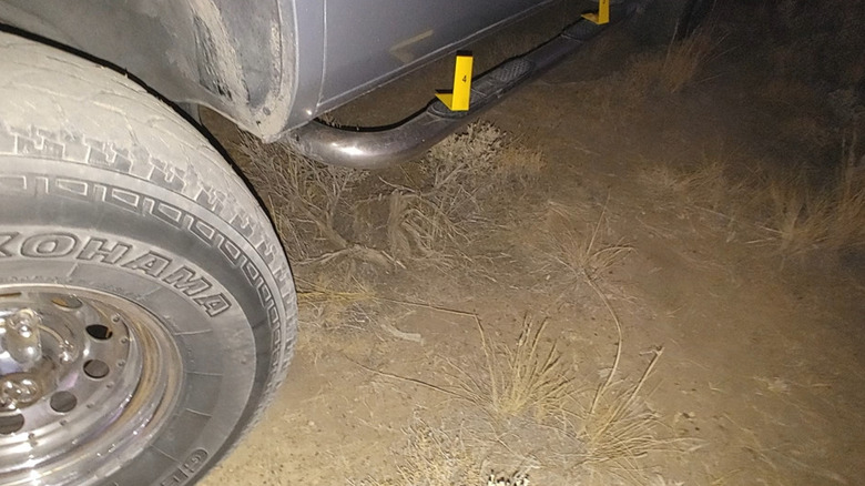 Footprints in dirt by a truck tire