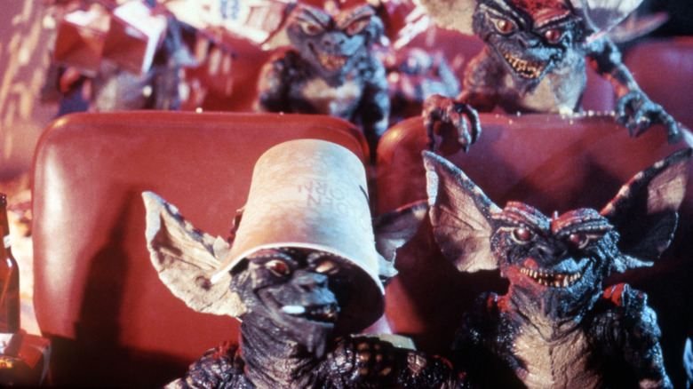 Gremlins sit in a movie theater in "Gremlins" (1984)