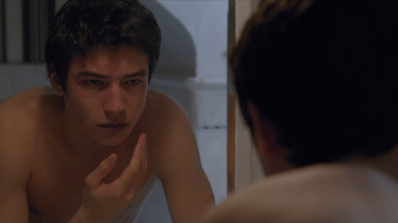 Ezra Miller shirtless looking in the mirror