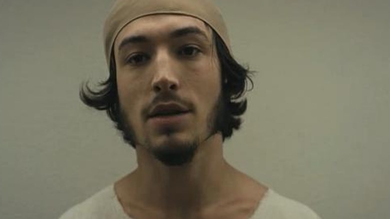 Ezra Miller with a goatee as a prisoner 