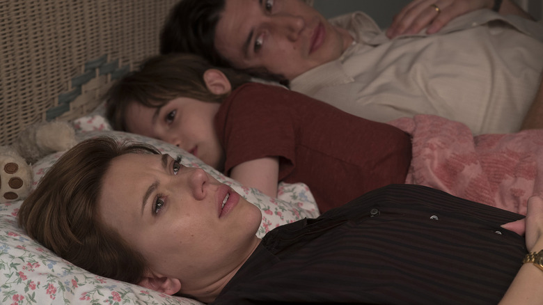 Johansson, Robertson, and Driver lying in a bed together