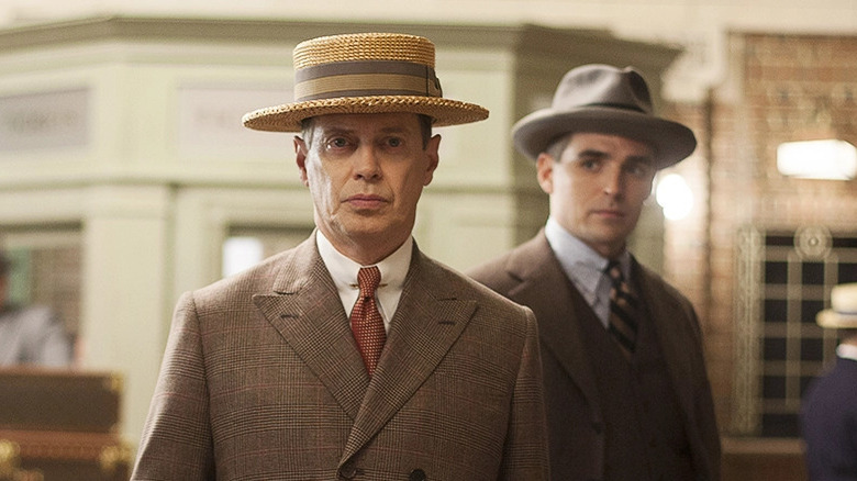 Nucky looks forward in a straw hat