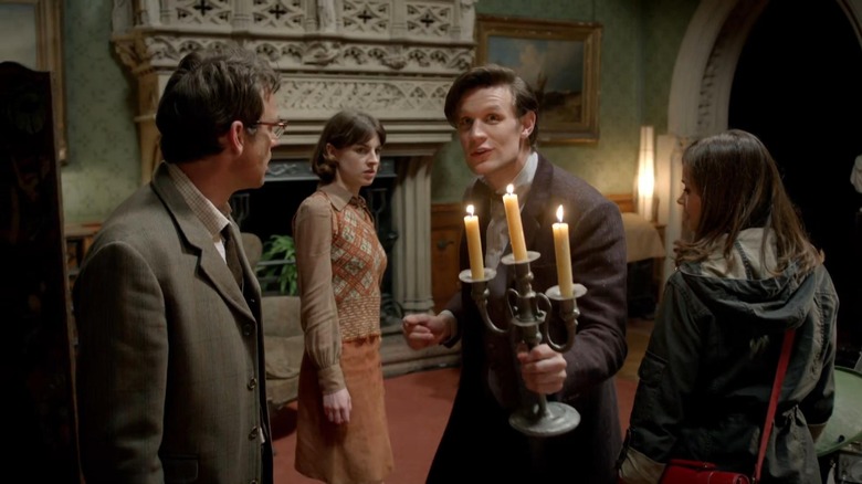 The Doctor holds a candlestick