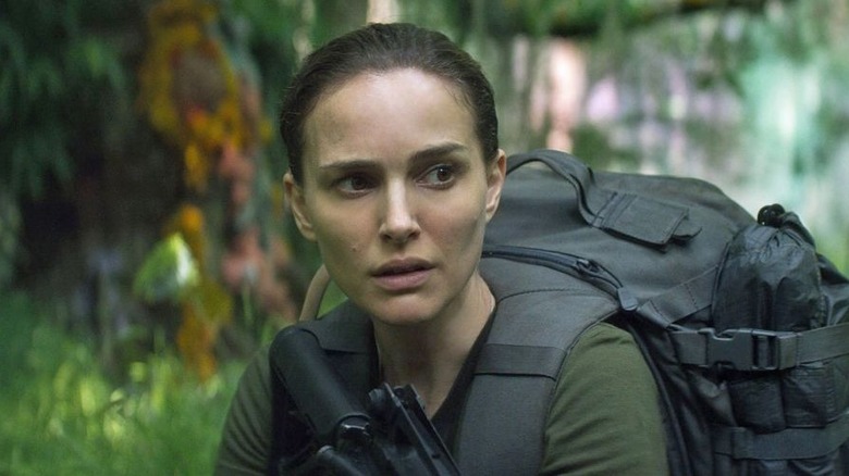 Lena walks through the jungle with a gun