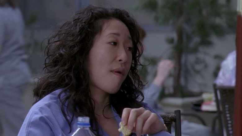 Cristina Yang staring snarkily while eating a cracker