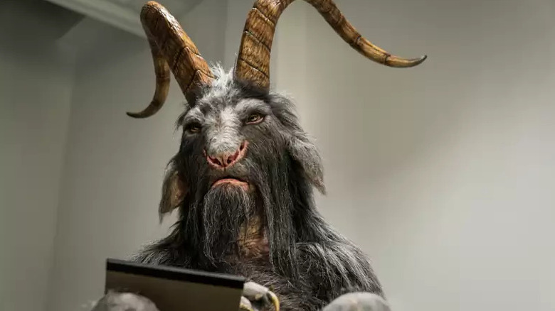 Horned goat man reads pad