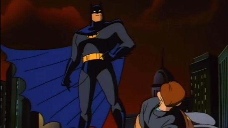 Batman stands over a crook