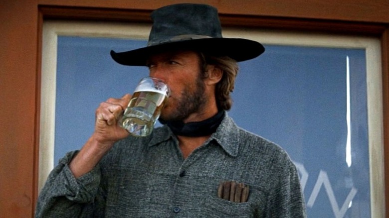 The Stranger drinking a beer outside a saloon in High Plains Drifter