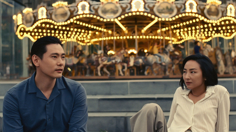 Hae Sung and Nora sitting in front of a carousel