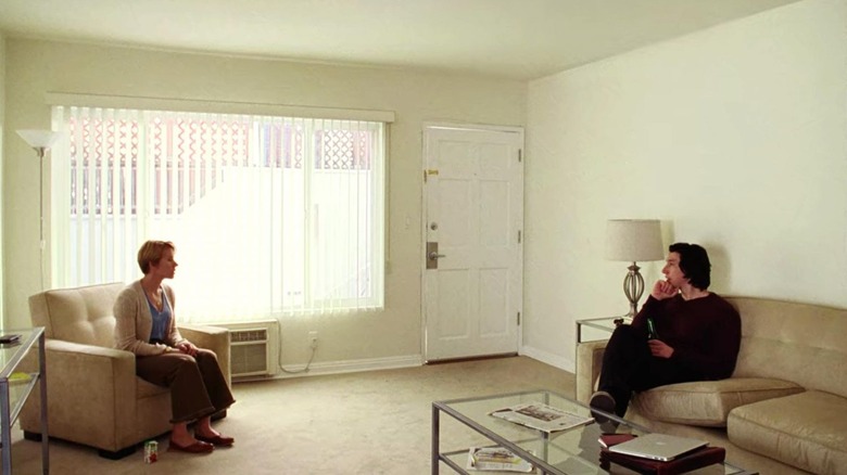 Nicole and Charlie sitting on opposite ends of a living room in Marriage Story